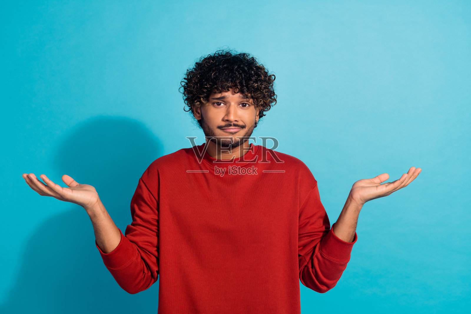 笨手笨脚的人举手耸肩不知道的肖像孤立在蓝色的背景上照片摄影图片