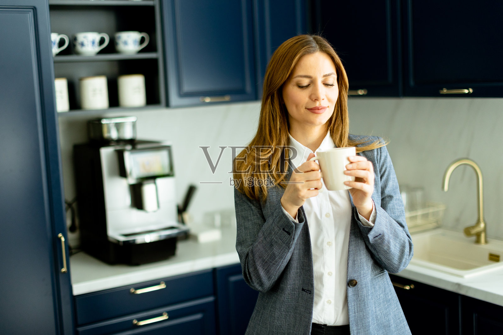 自信的女商人在现代办公室厨房享受咖啡休息时间照片摄影图片