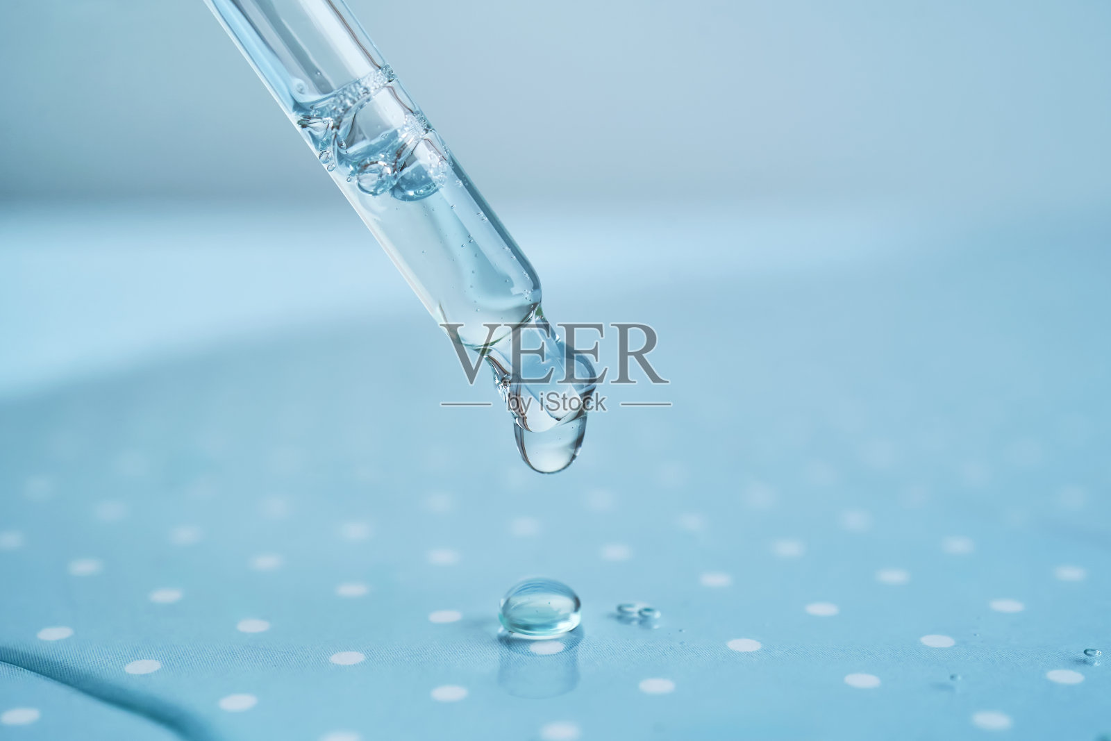 蓝色背景的血清移液管。照片摄影图片