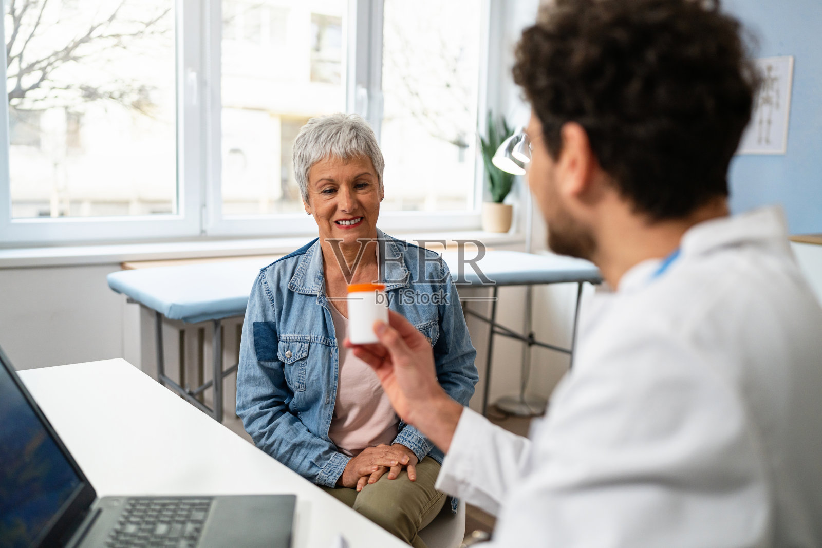 医生向一位老年女病人讲解药物的副作用和正确的使用方法照片摄影图片