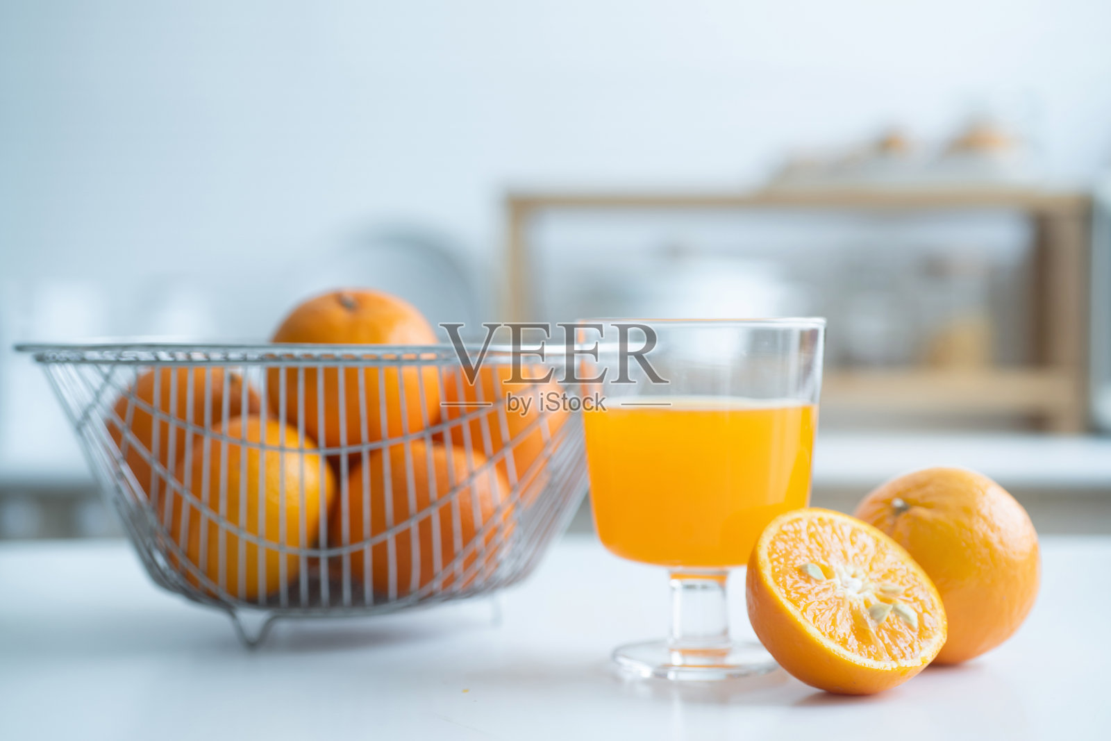 在家里的厨房里，早餐桌上摆着橙色水果和一杯橙汁，选择性地集中在一起照片摄影图片