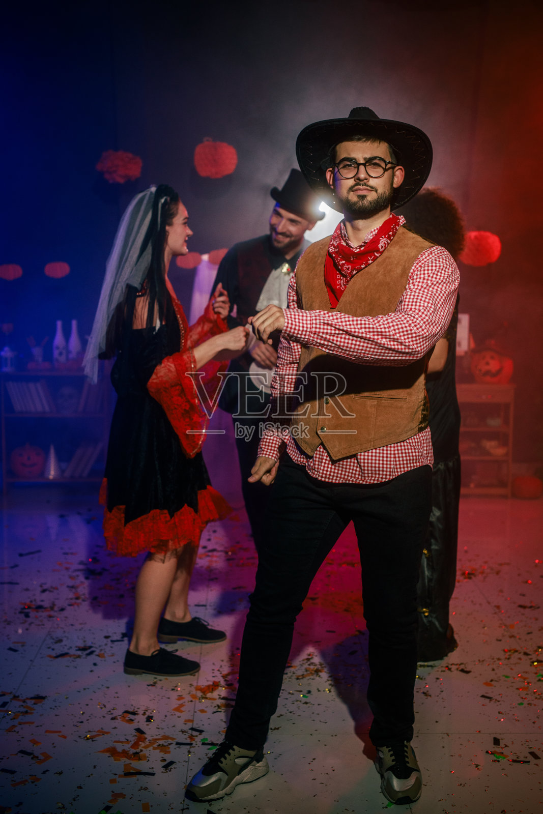 一个穿着牛仔服装的快乐年轻人在万圣节派对上跳舞照片摄影图片