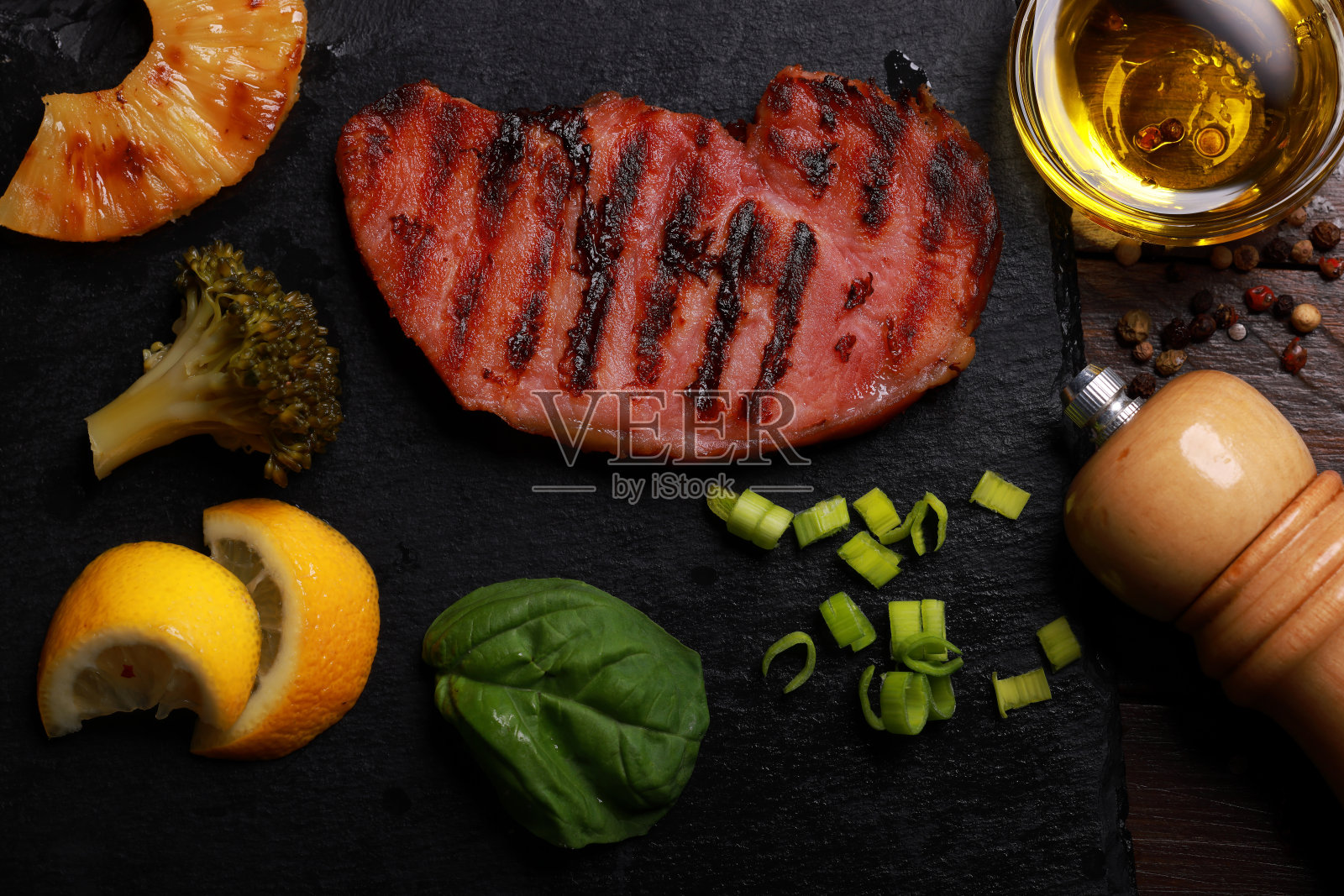 石板拼盘上的猪排和菠萝照片摄影图片