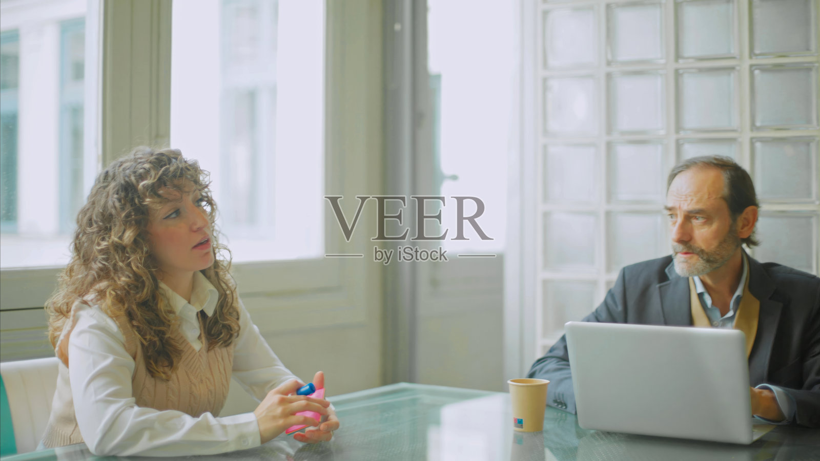 卷发女人正在进行严肃的商业对话照片摄影图片