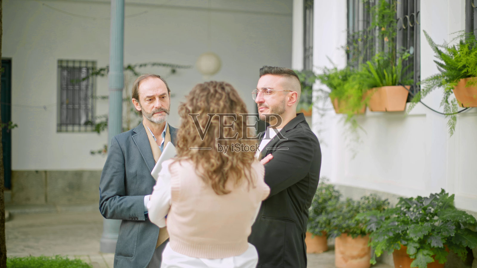 三位专业人士在绿色的室外庭院里讨论照片摄影图片