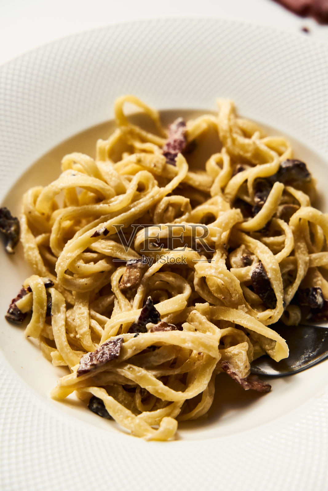 阿尔弗雷多意大利面与香菇和洋蓟在白色大理石背景。极简的食物照片。照片摄影图片