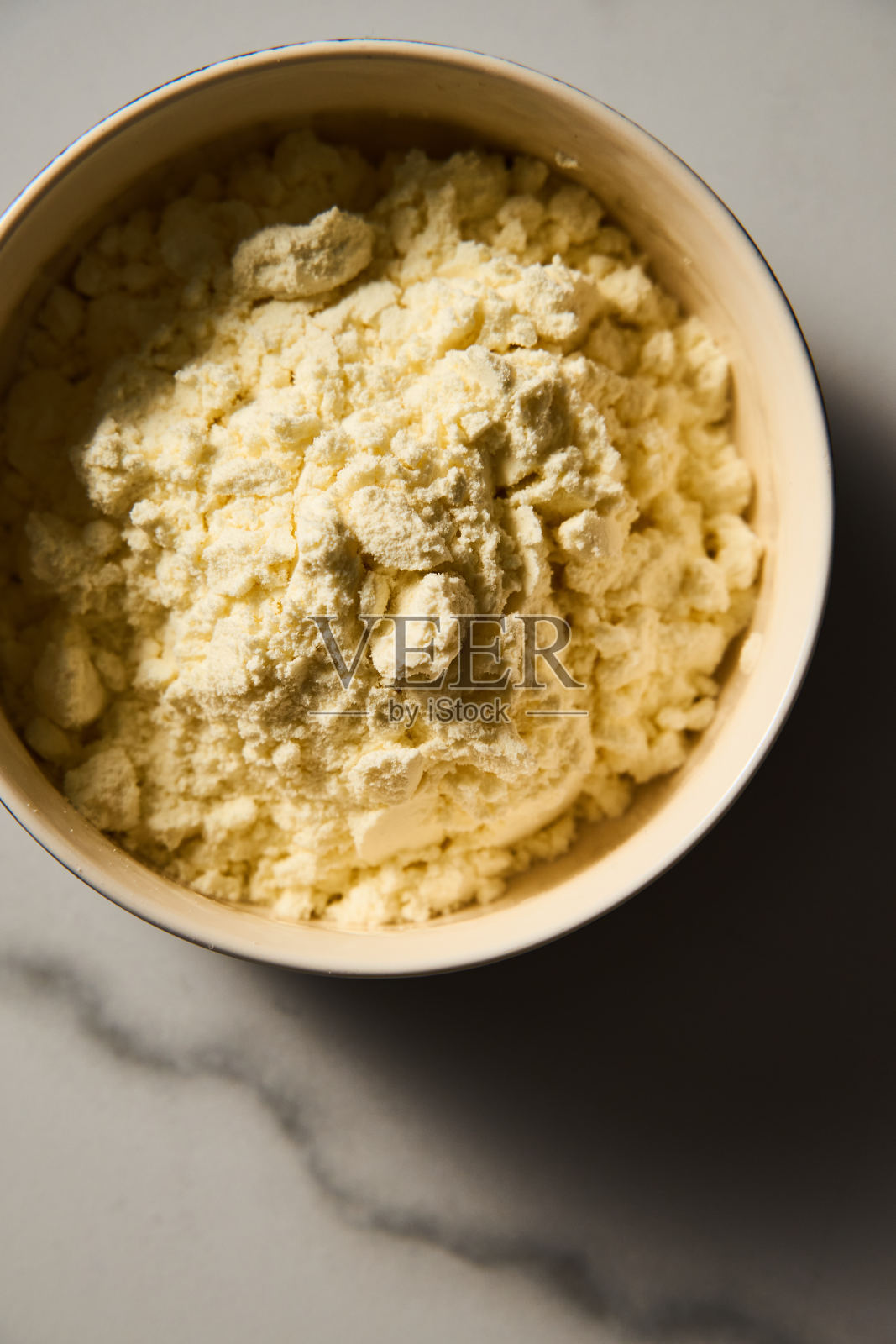 干奶粉。脱水奶粉在白色大理石背景碗，极简主义的食物照片。照片摄影图片