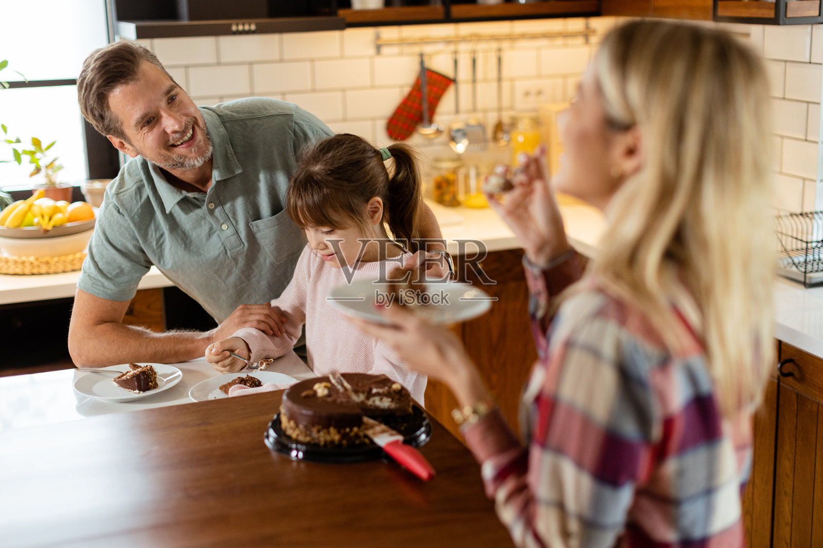 快乐的家庭在舒适的厨房享受自制巧克力蛋糕照片摄影图片