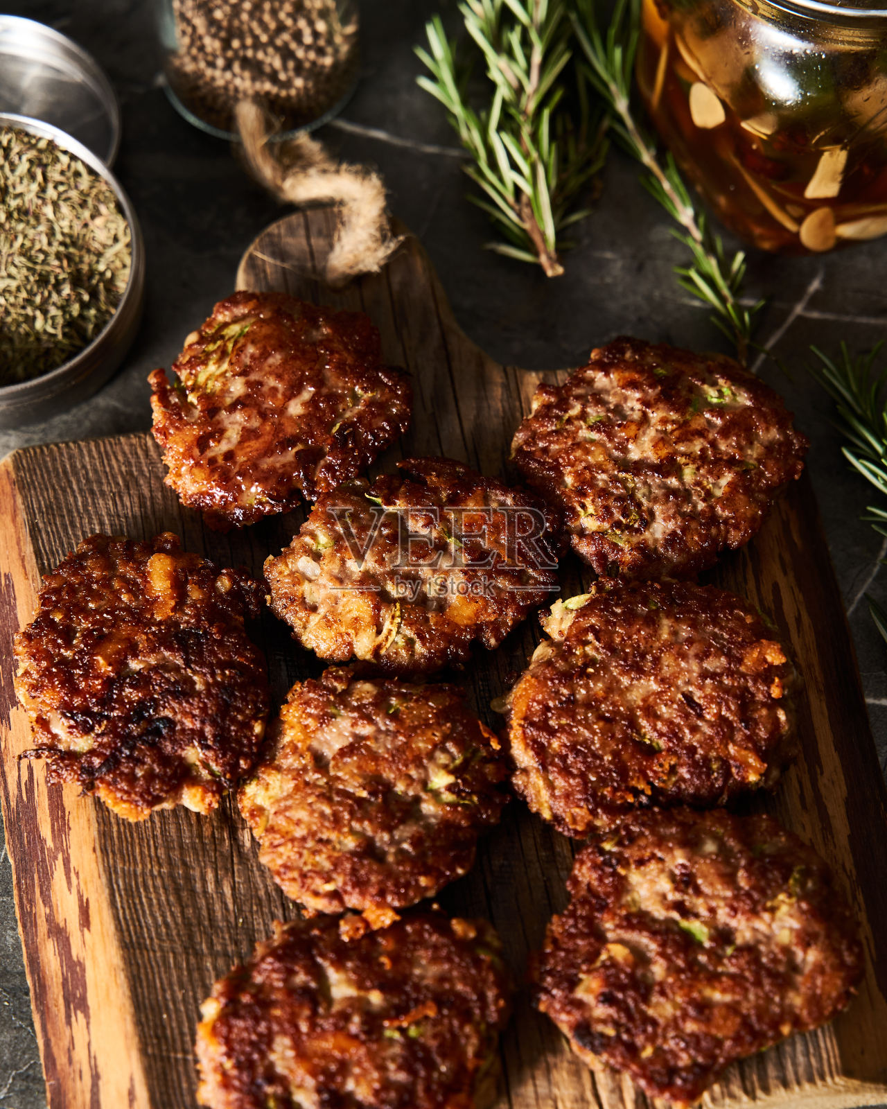 牛肉，西葫芦和切达奶酪馅饼或肉片在木板上。低调的食物照片，深色背景。晚餐肉类概念，富含蛋白质。照片摄影图片