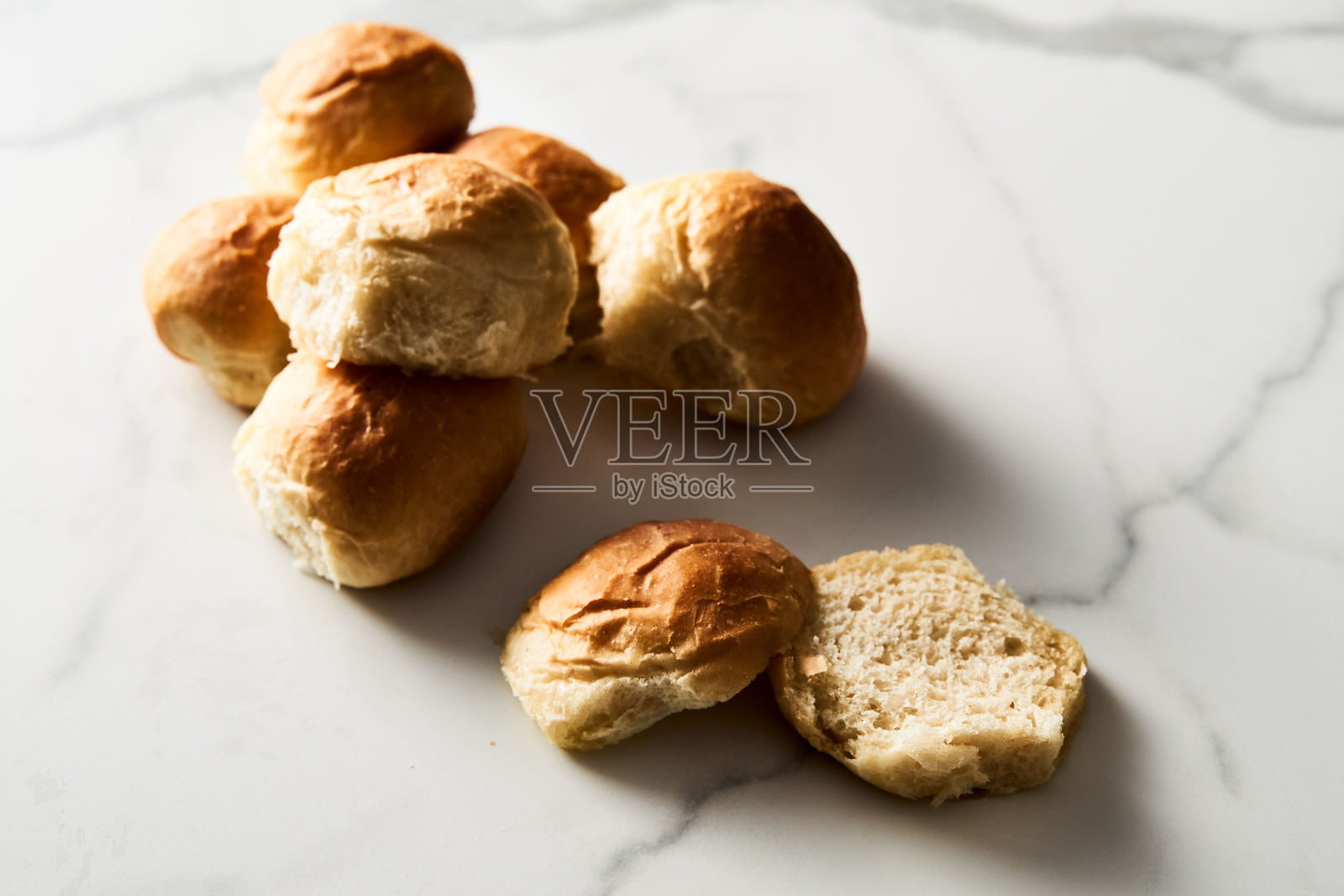 汉堡包子或迷你包子在白色大理石背景。非常柔软的新鲜出炉的自制，涂了黄油。简约的照片。照片摄影图片