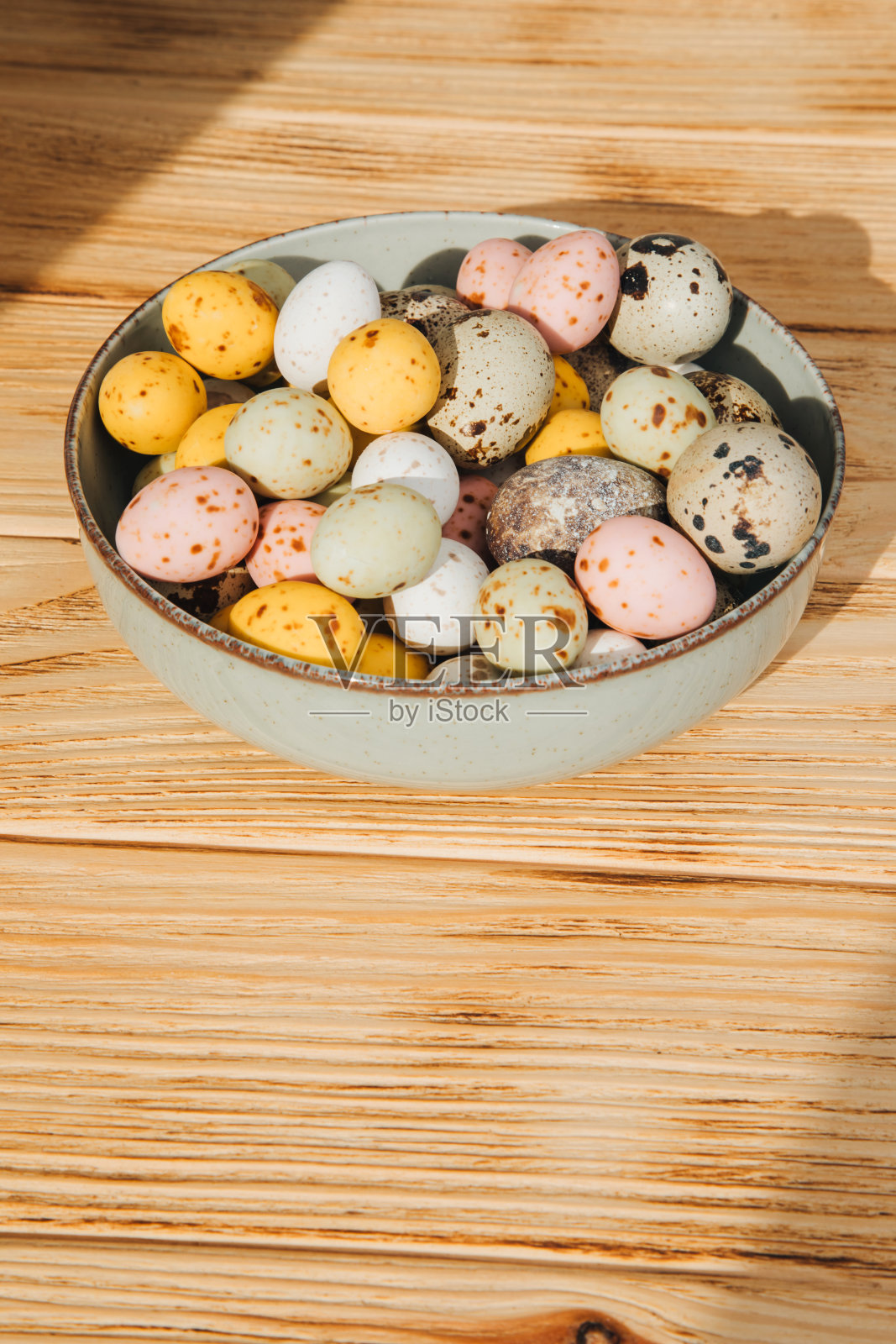 多色巧克力装饰蛋和鹌鹑蛋在绿色盘子木制背景照片摄影图片
