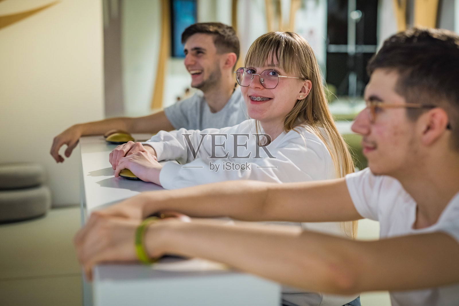 三个十几岁的学生在互动式博物馆展览中玩得很开心照片摄影图片