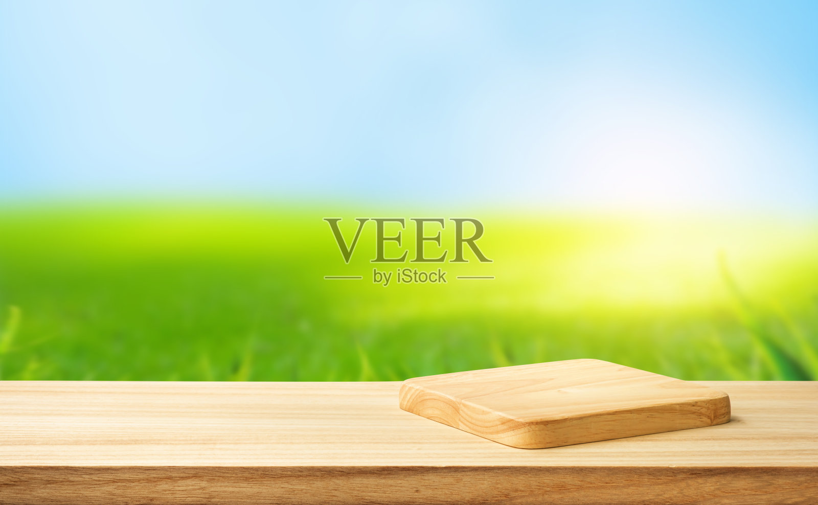 有选择性的重点。木质台面与砧板上模糊绿色草坪草的背景照片摄影图片