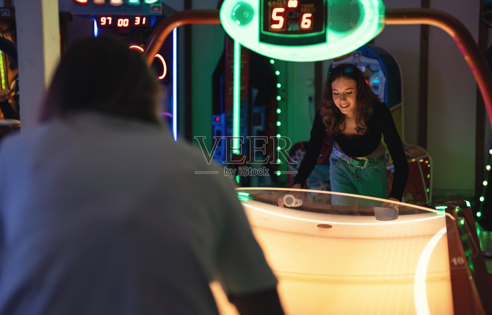 女孩在娱乐中心打空中曲棍球。照片摄影图片