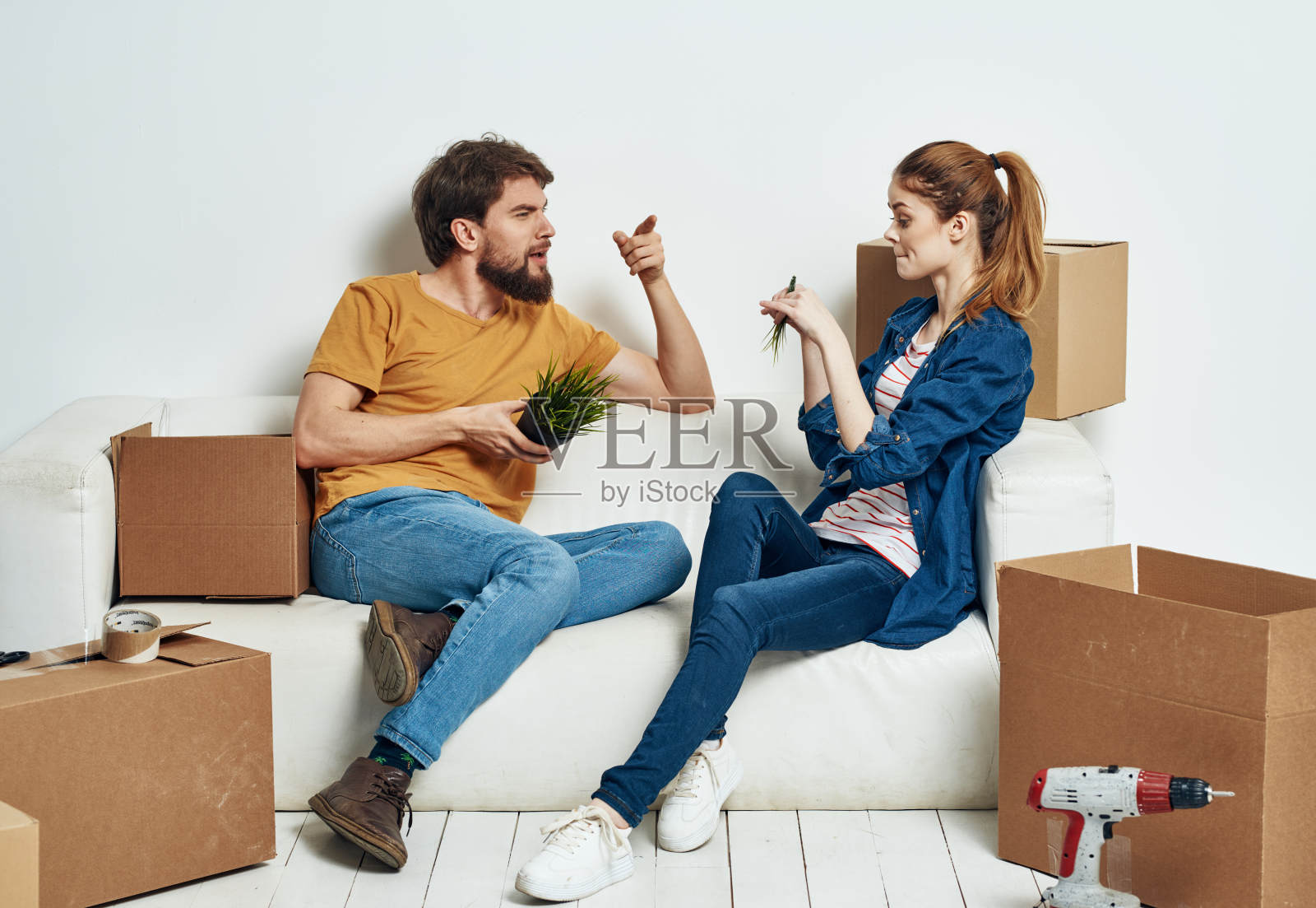 一对快乐的年轻夫妇住在公寓里，箱子里的东西在移动照片摄影图片