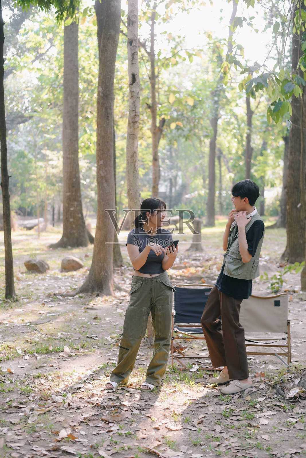 亚洲夫妇在营地边碰杯咖啡，在大自然中露营，他们感到放松和清爽。娱乐照片摄影图片