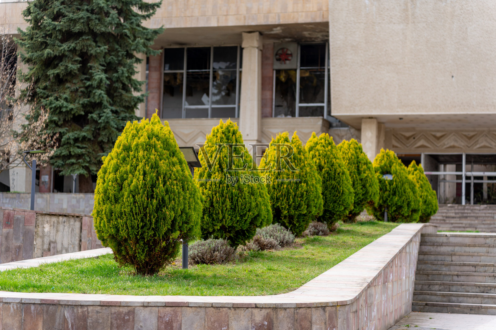 建筑物的外景，两侧有草和树照片摄影图片