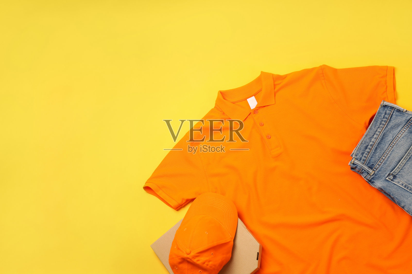 黄色背景上披萨盒的快递员空白制服照片摄影图片