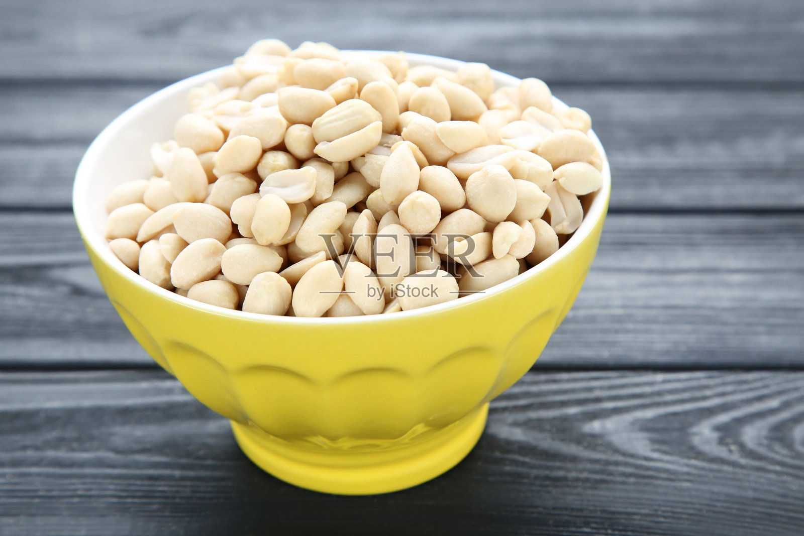 黑色木桌上碗里的花生照片摄影图片