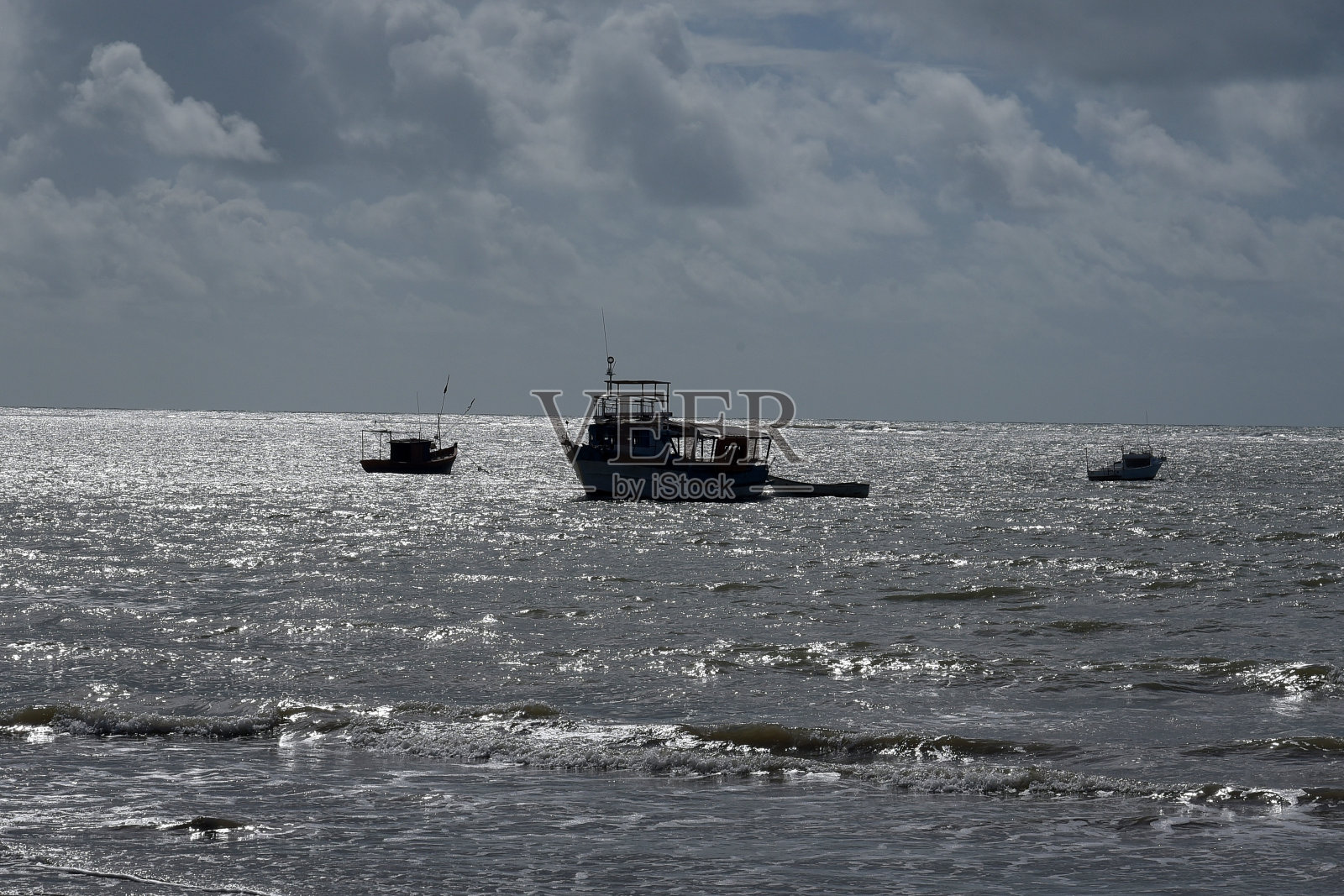 老渔民的船被遗弃在肮脏的海滩上，垃圾污染了渔民照片摄影图片