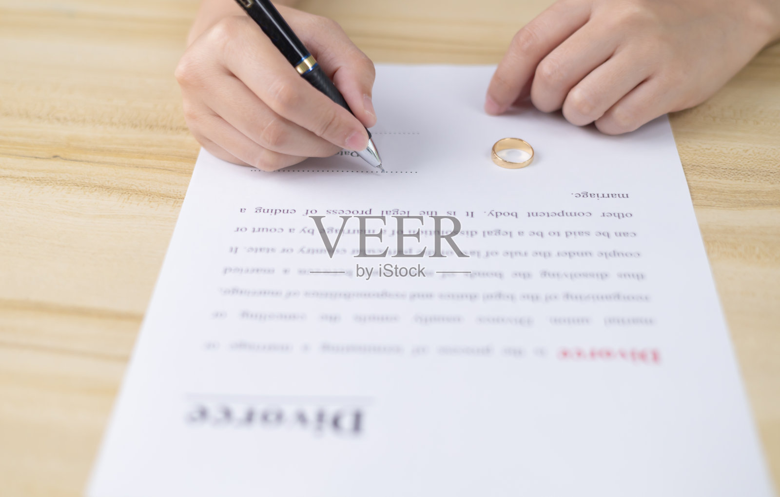 离婚过程中签署离婚协议的女人，离婚证上放着结婚戒指，离婚和分居概念，冲突，结束婚姻，离婚法照片摄影图片