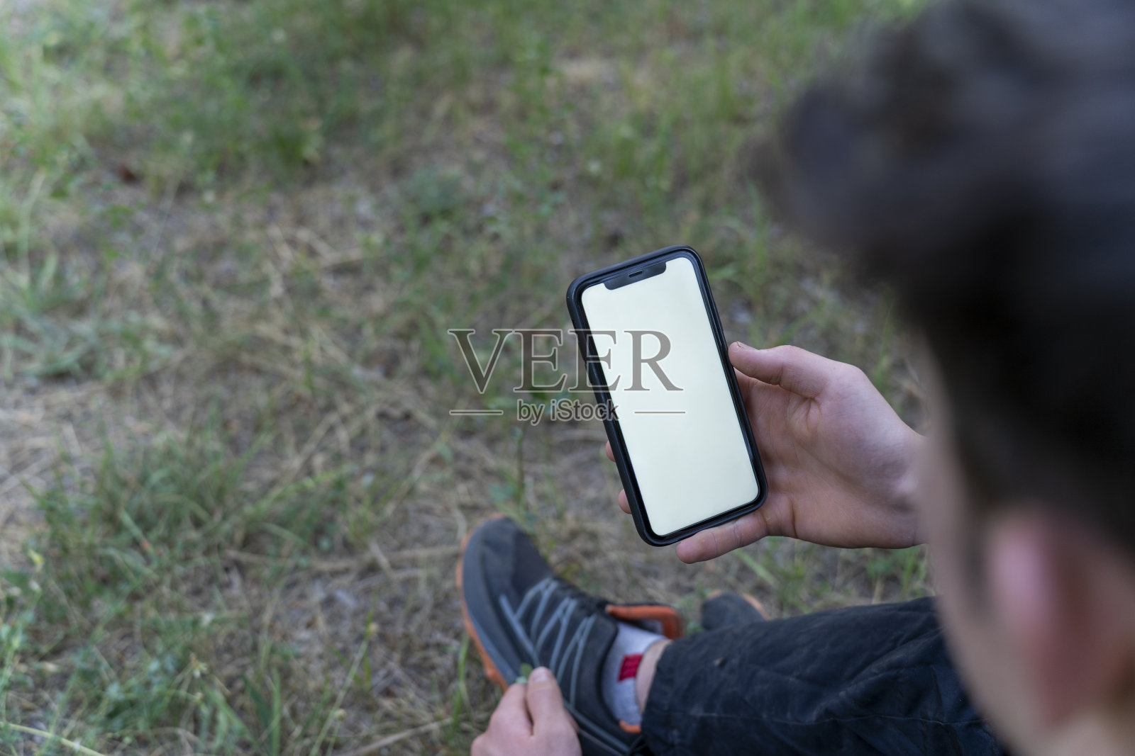 森林中一个男人手中的模拟智能手机，背景是树木。关于户外休闲旅游主题的概念。照片摄影图片