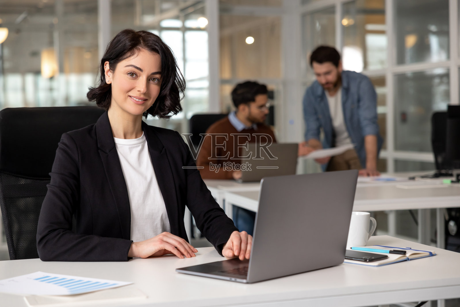 女企业家在办公室会议室用笔记本电脑和团队在后台工作照片摄影图片