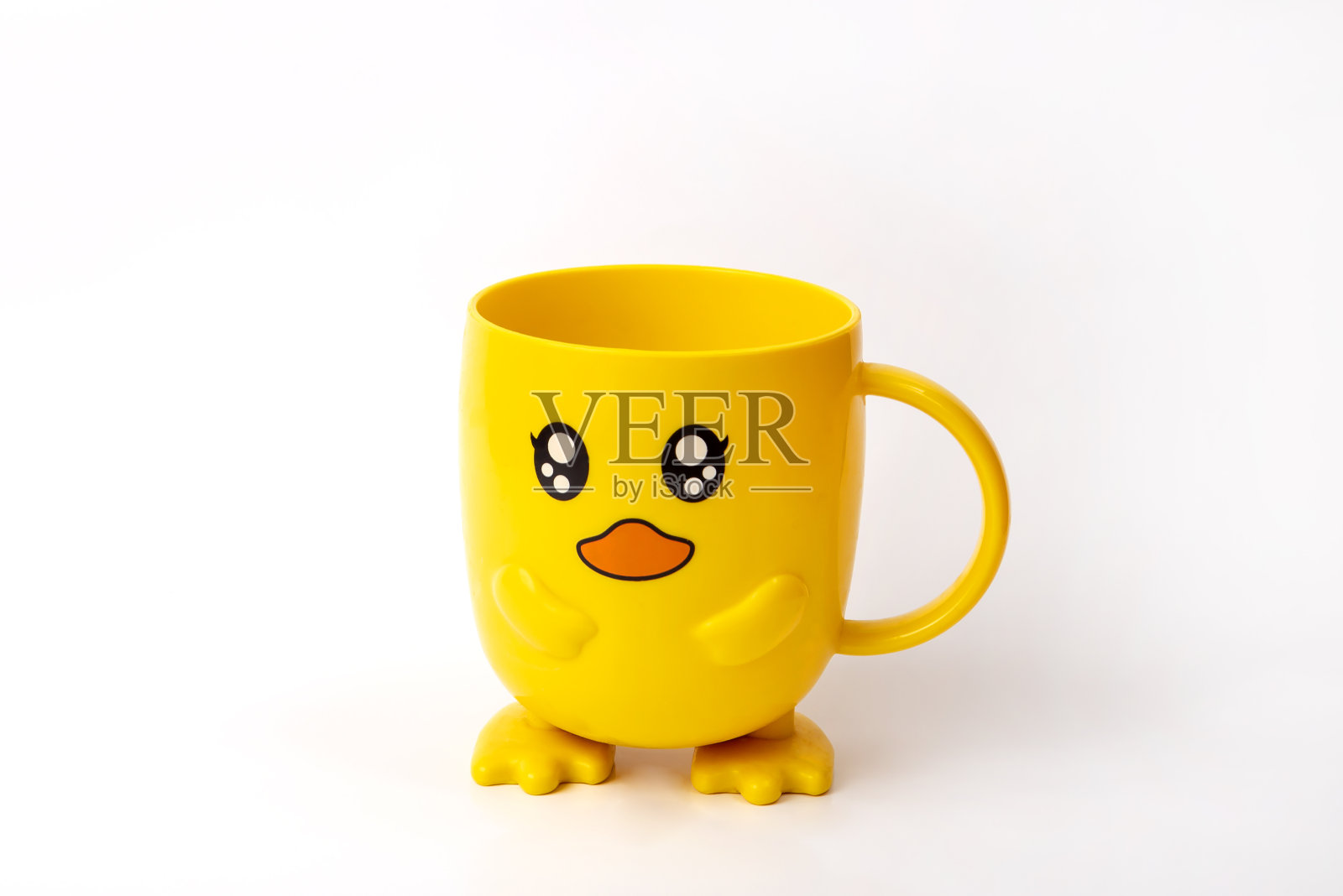 白色背景上的黄色杯子。杯子有眼睛。给孩子的漂亮杯子。生日礼物。照片摄影图片