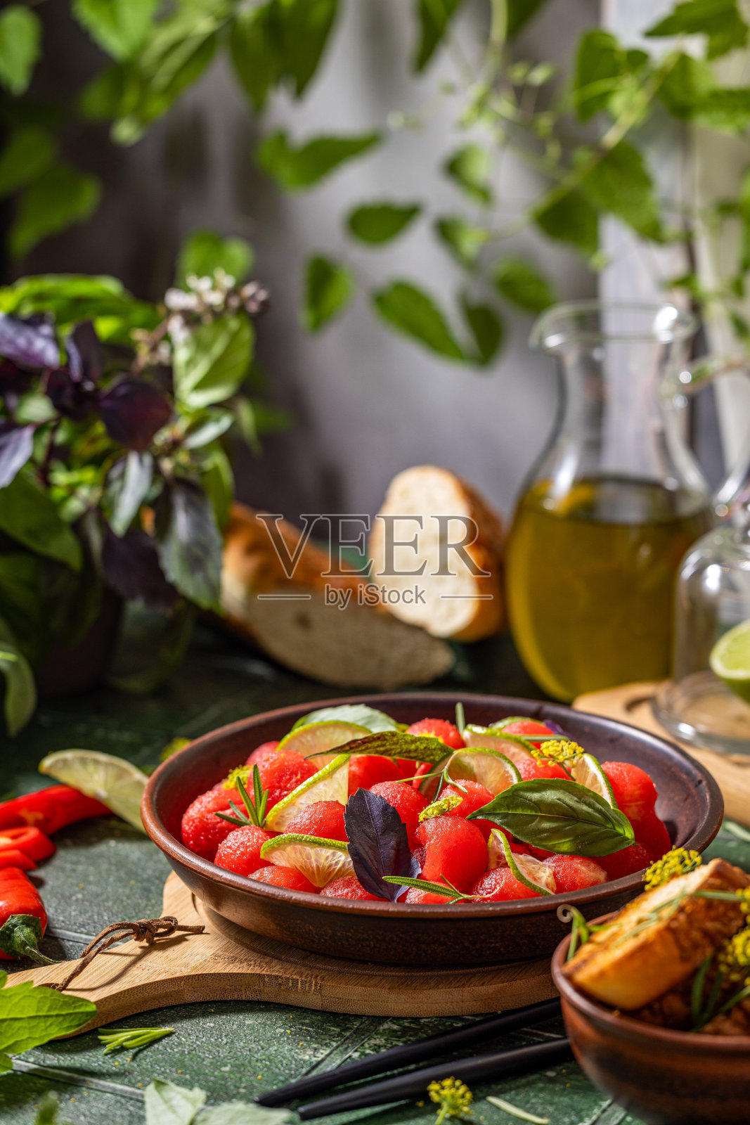 新鲜西瓜球配以罗勒、青柠、迷迭香和茴香，配以橄榄油制成的辛辣沙拉照片摄影图片