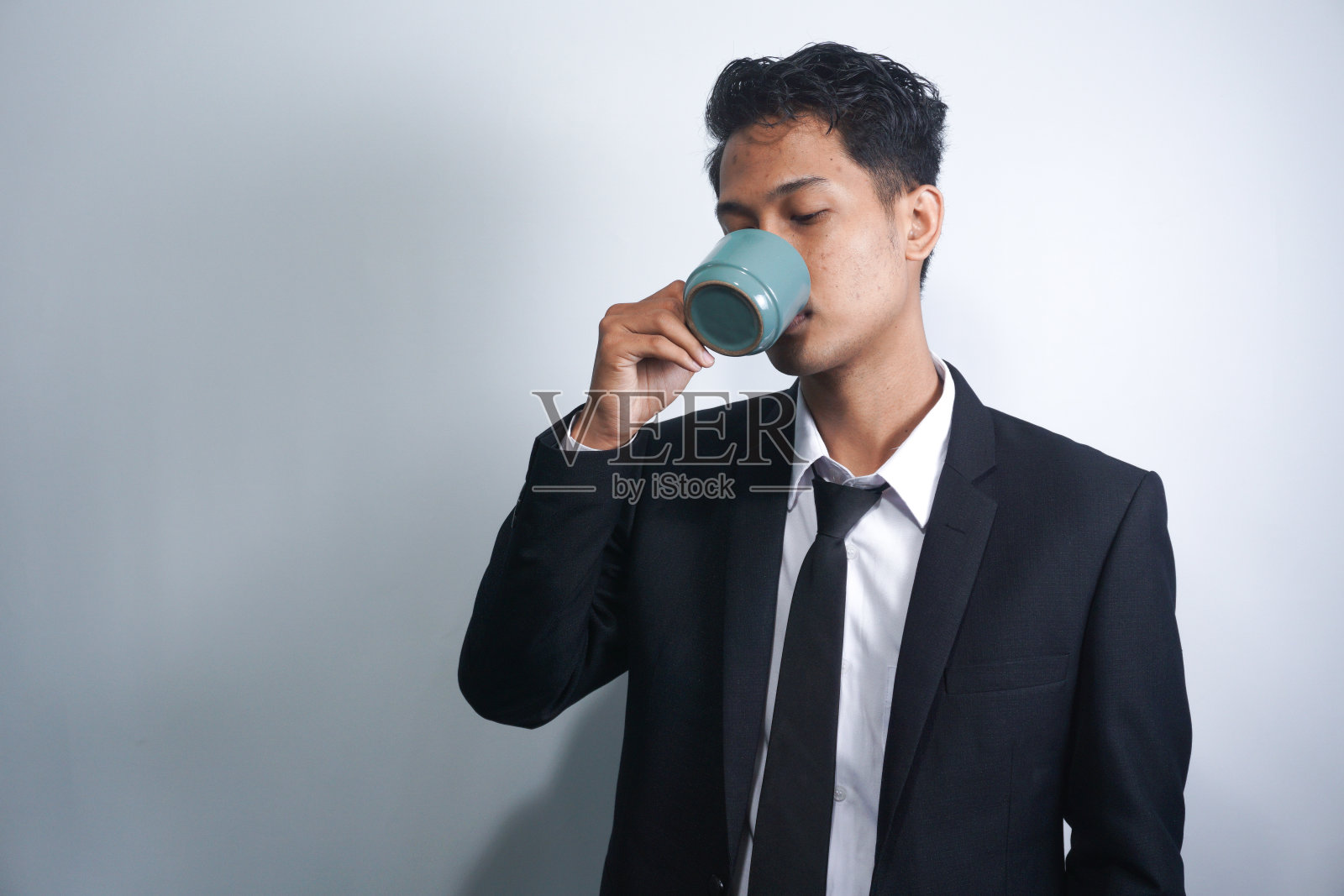 照片中，一些穿着西装的欢快的商人，看着相机，手里拿着一杯咖啡，背景是孤立的照片摄影图片