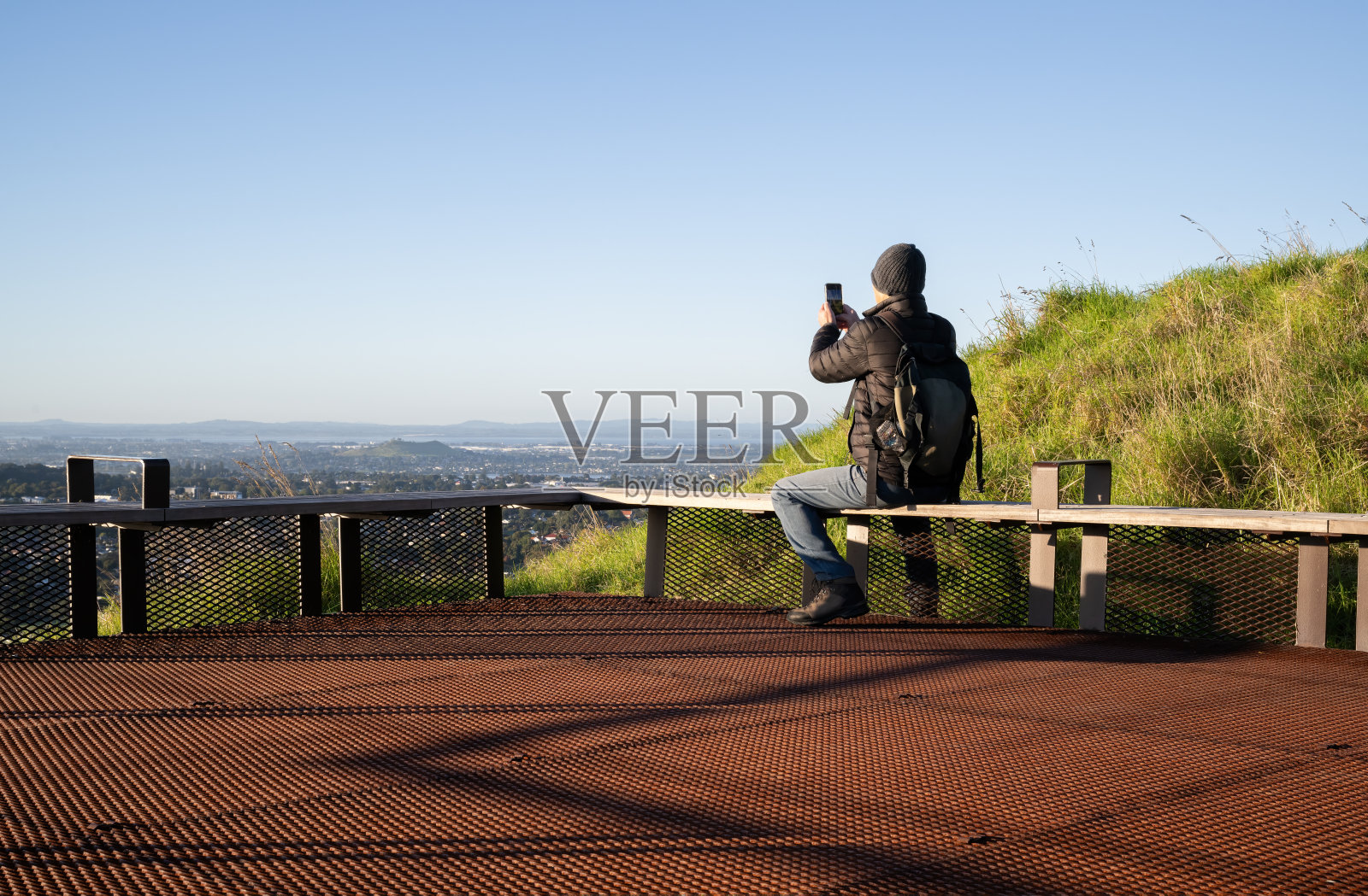 男子用智能手机拍照。伊甸山顶。奥克兰。照片摄影图片