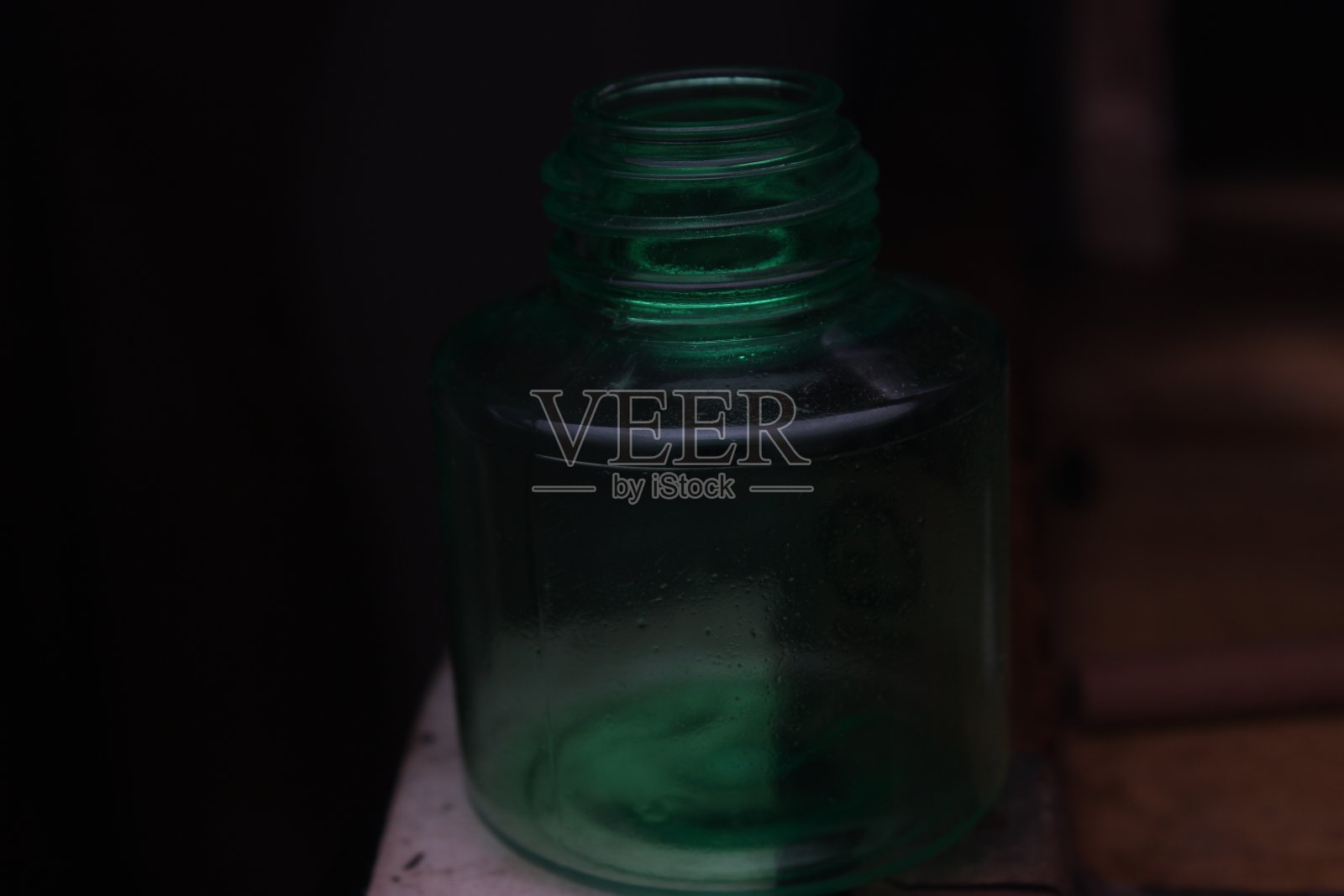 一个空的透明绿色15毫米无品牌的瓶子在黑色背景上拍摄照片摄影图片