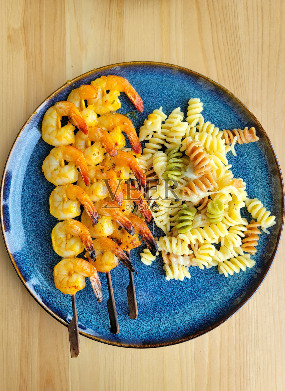 蓝盘子里有虾串和意大利面照片摄影图片