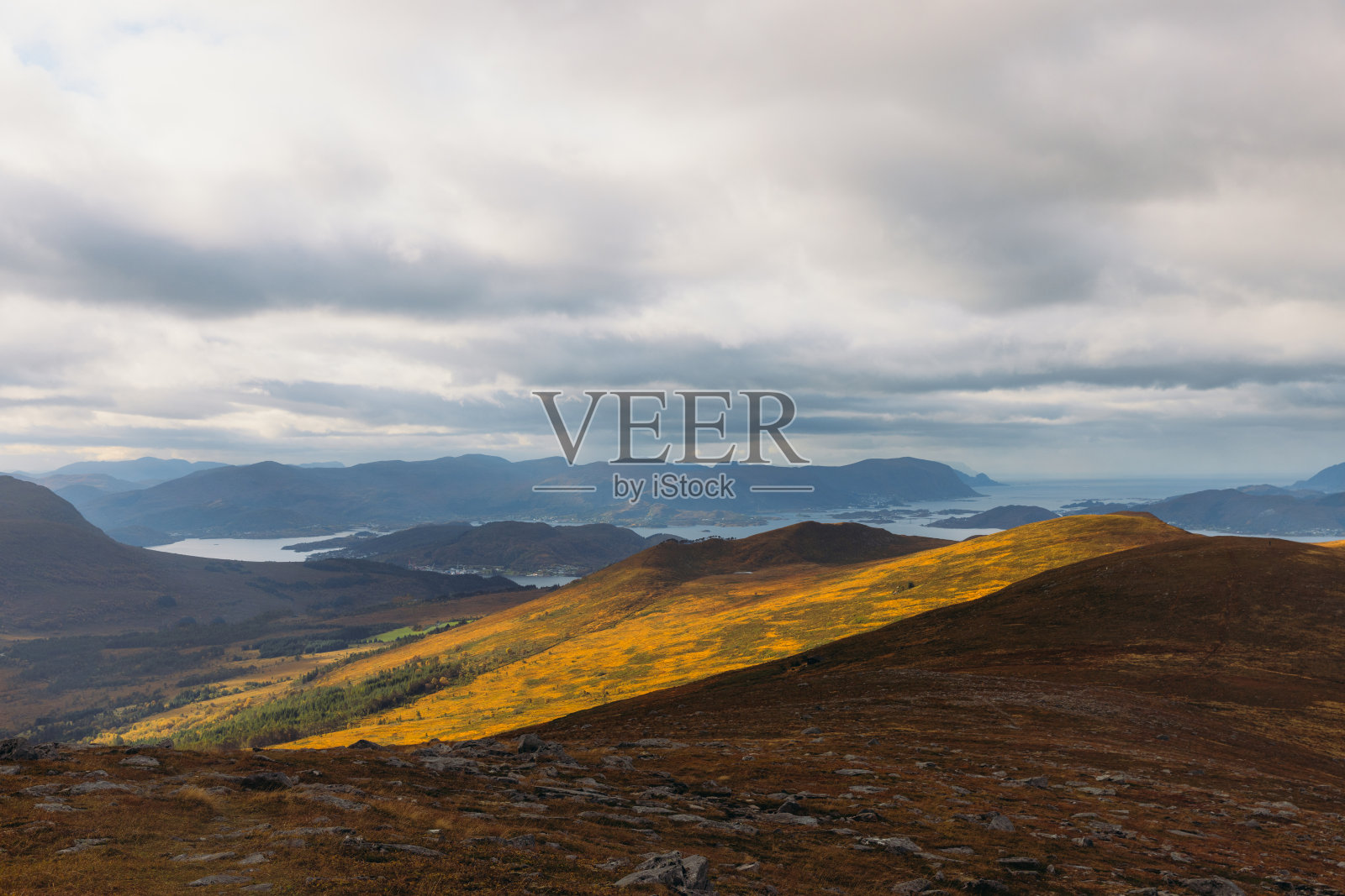 发光的日落山丘陵与海景照片摄影图片