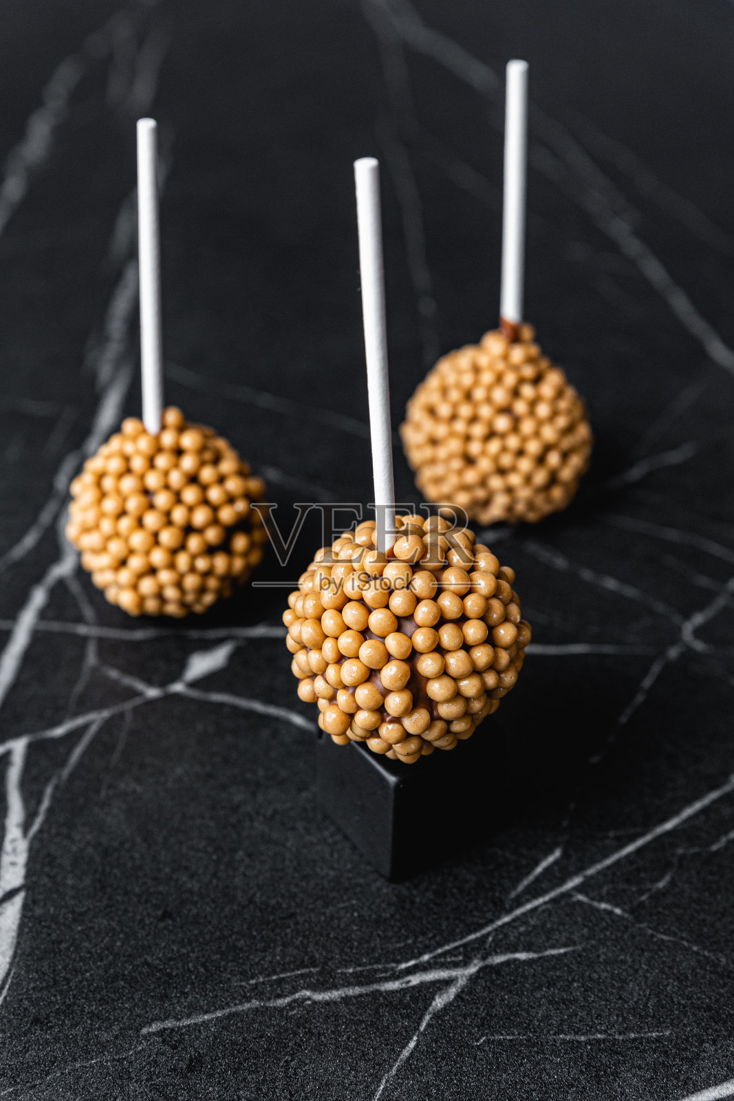 美味的巧克力棒棒糖蛋糕配上金色的糖屑照片摄影图片