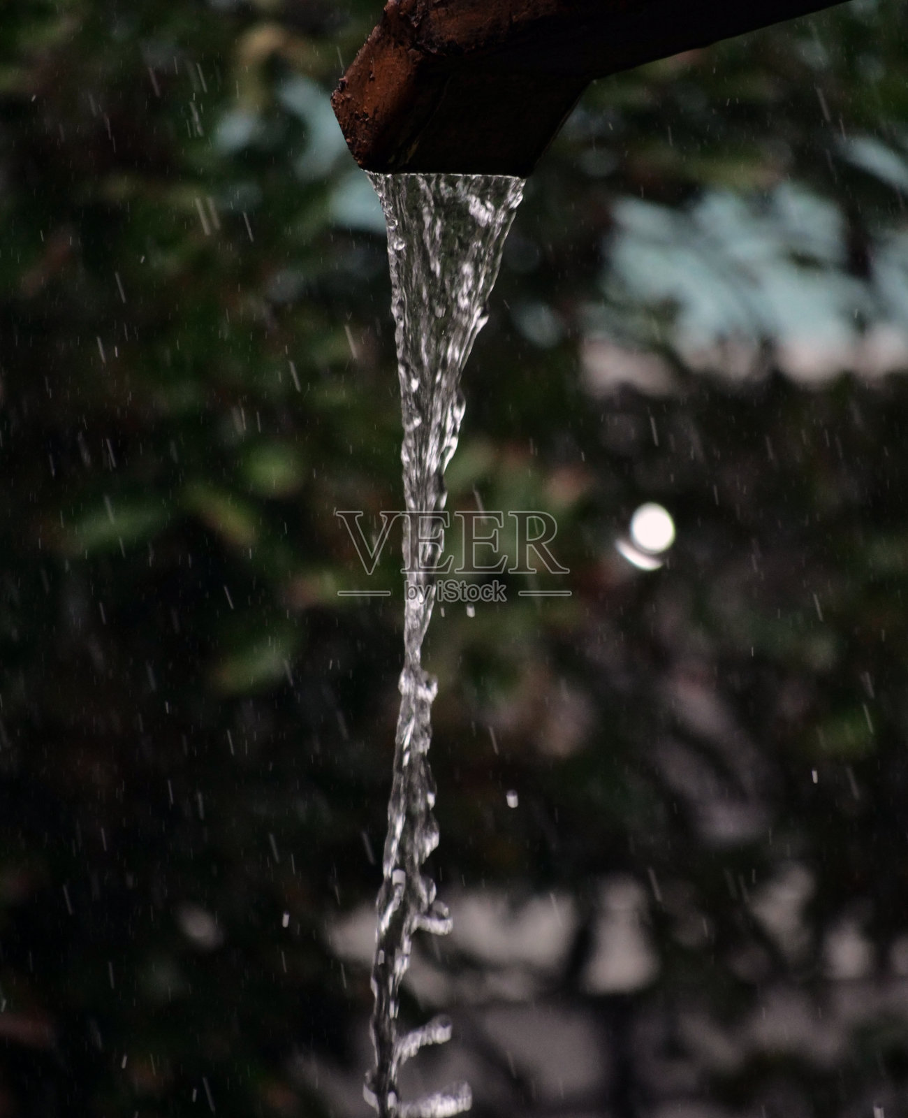 雨水从排水沟里落下。照片摄影图片