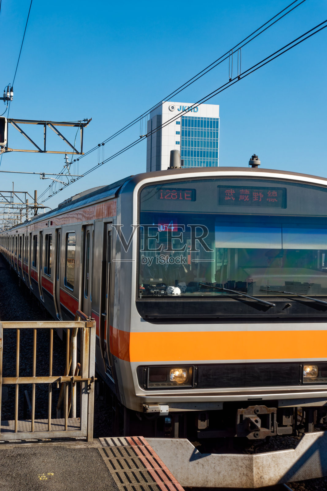 以蓝天为背景，抵达东京大都市火车站的地区列车。照片摄影图片