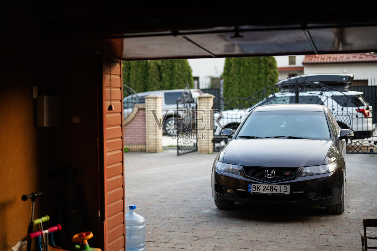 一辆黑色本田雅阁轿车停在一户人家的车道上，为家庭出游或日常通勤做好了准备。照片摄影图片