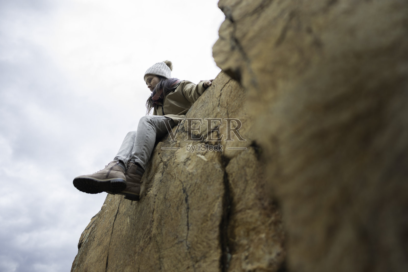 女人坐在悬崖上。回归自然的独自旅行。照片摄影图片