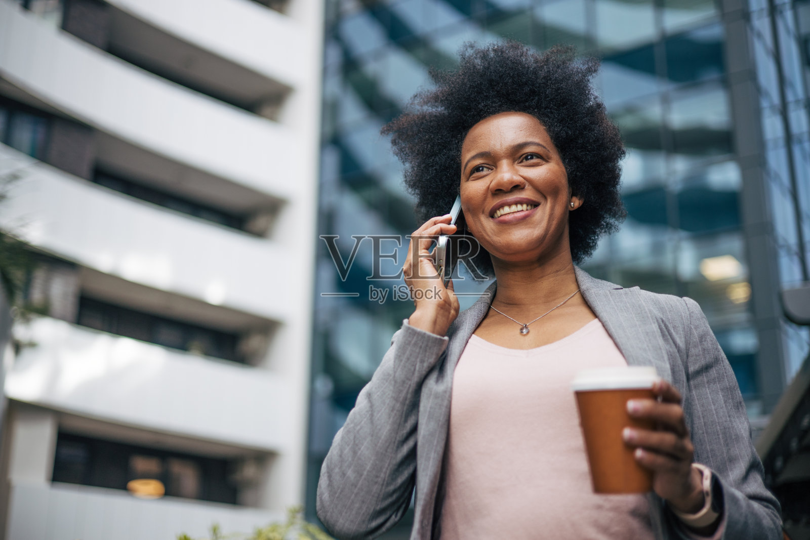 非洲女商人在喝咖啡休息时间打电话。照片摄影图片