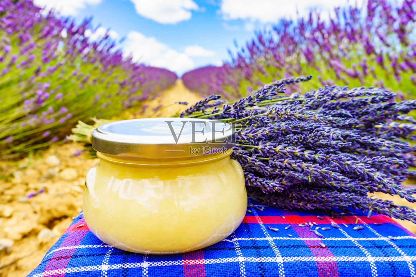 一罐蜂蜜和薰衣草花。照片摄影图片