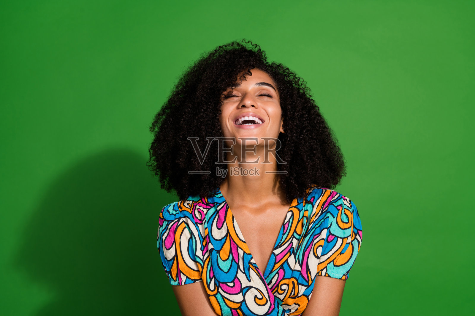 令人惊叹的闪亮甜美开朗的女孩穿着鲜艳鲜艳的衣服，好心情笑话笑孤立在绿色的背景照片摄影图片