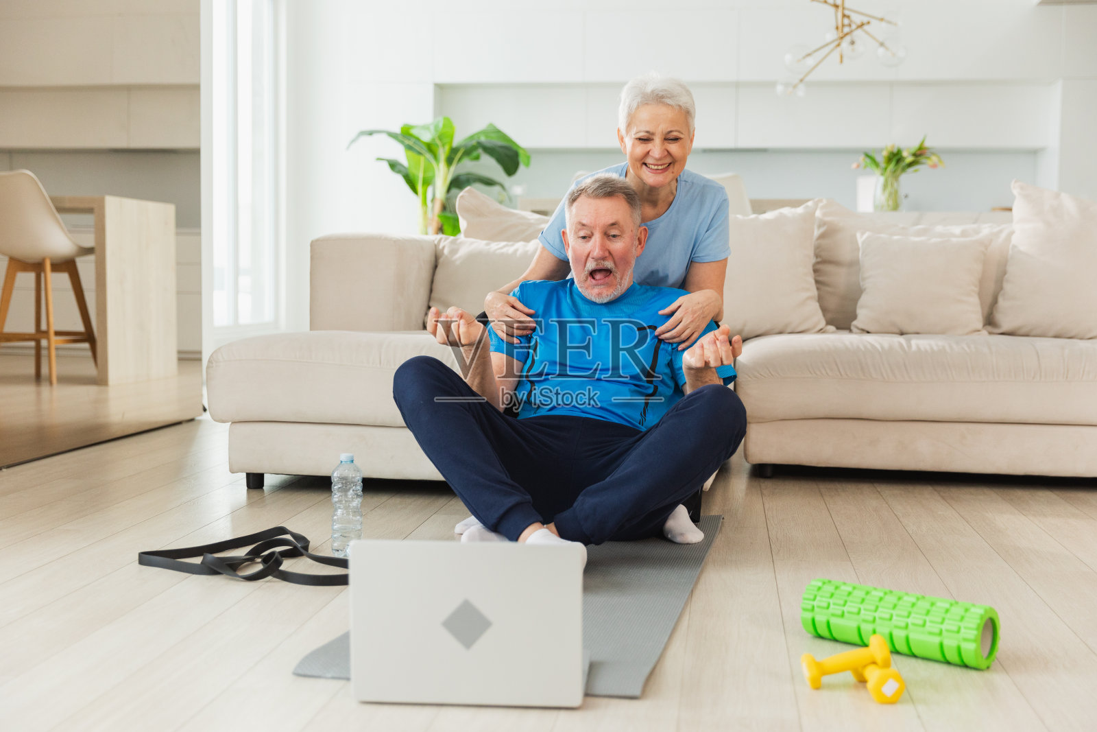 瑜伽正念冥想。成年夫妇在笔记本电脑上练习在线瑜伽课程。老伴帮助教丈夫冥想放松。家人在家做呼吸练习。照片摄影图片