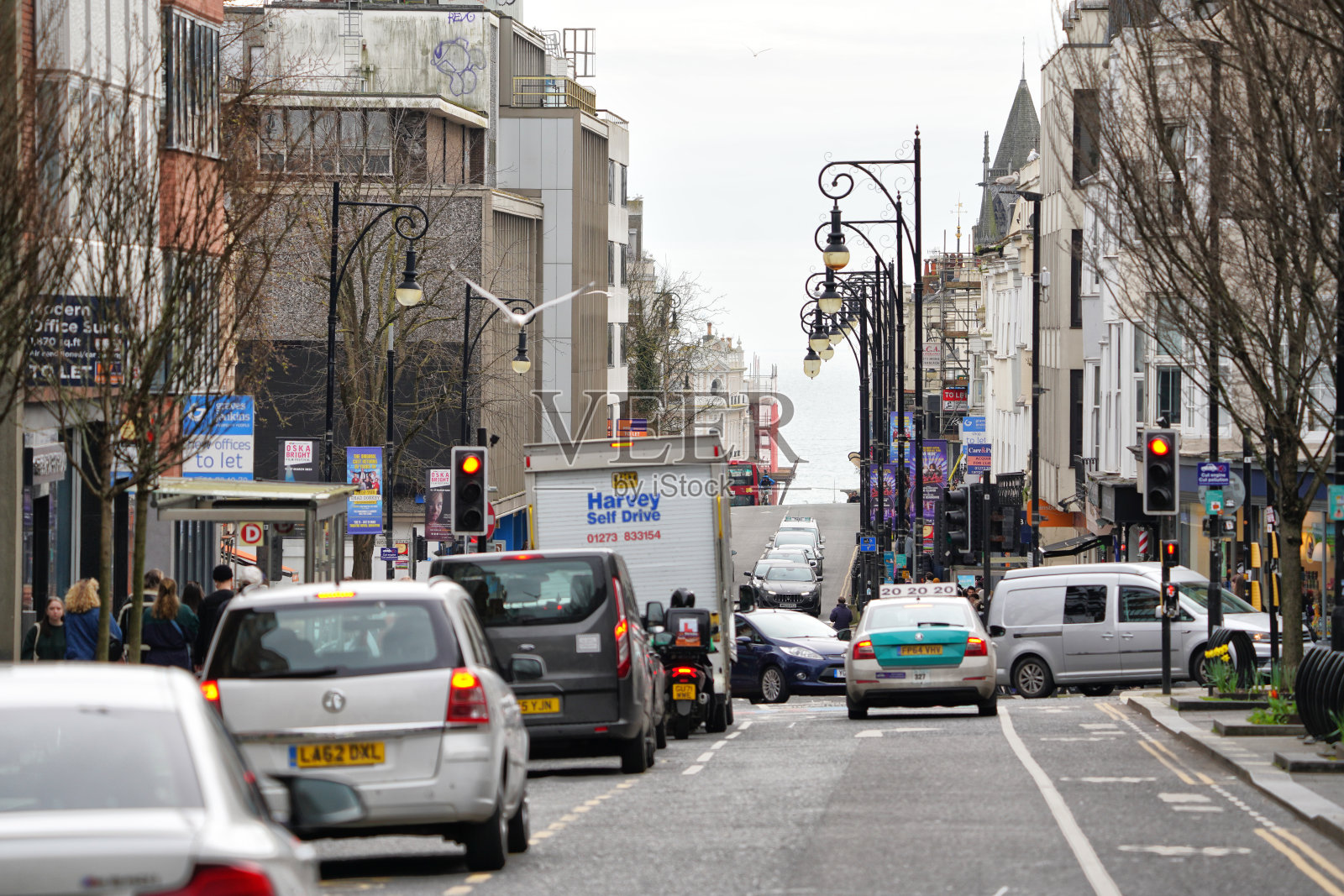 繁忙的城市生活：汽车交通流，人群，行人，皇后路，布莱顿和霍夫市中心的主要街道，东萨塞克斯，英国，欧洲，春日照片摄影图片