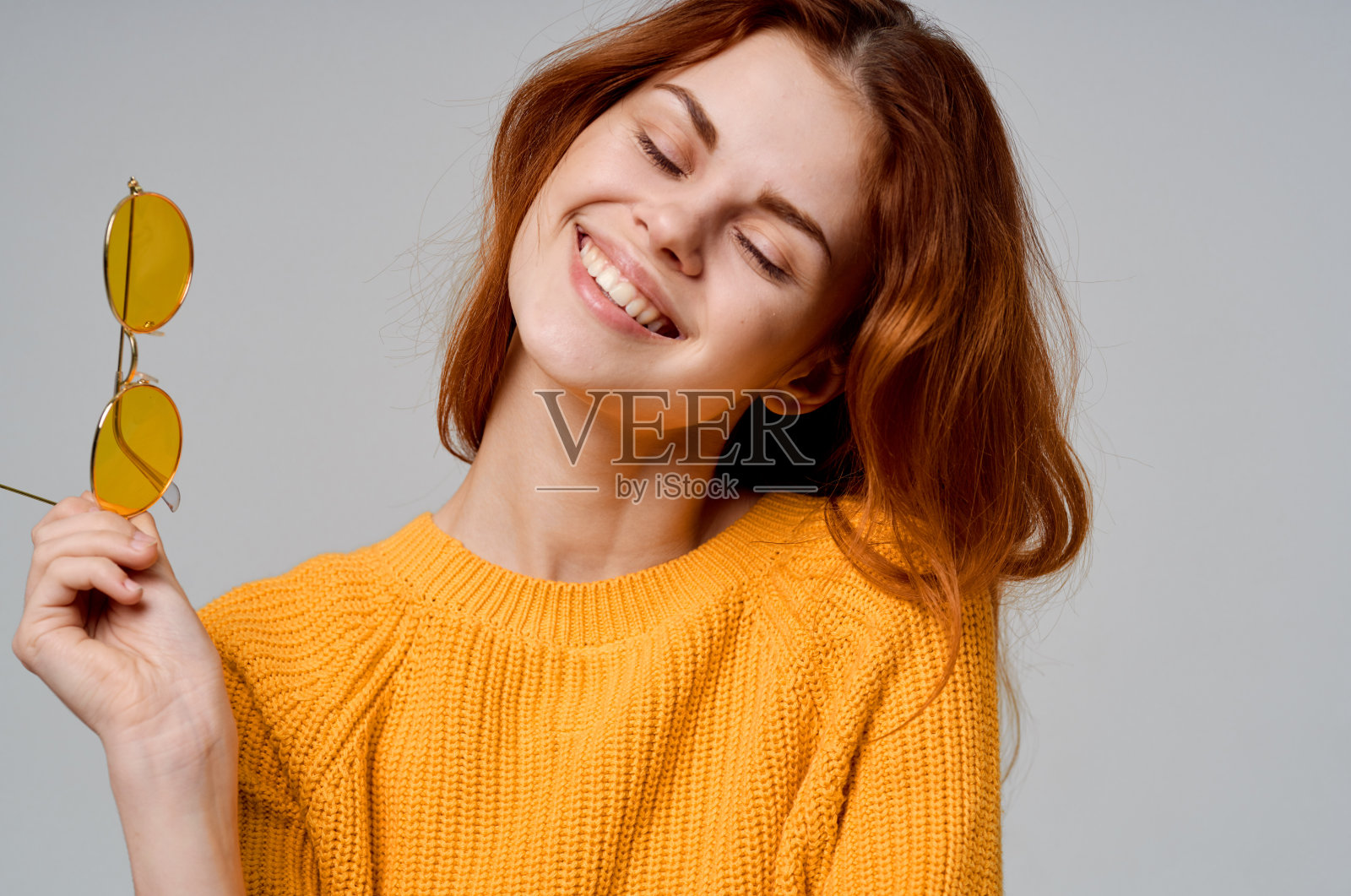 美女戴着黄色毛衣眼镜，笑容迷人照片摄影图片