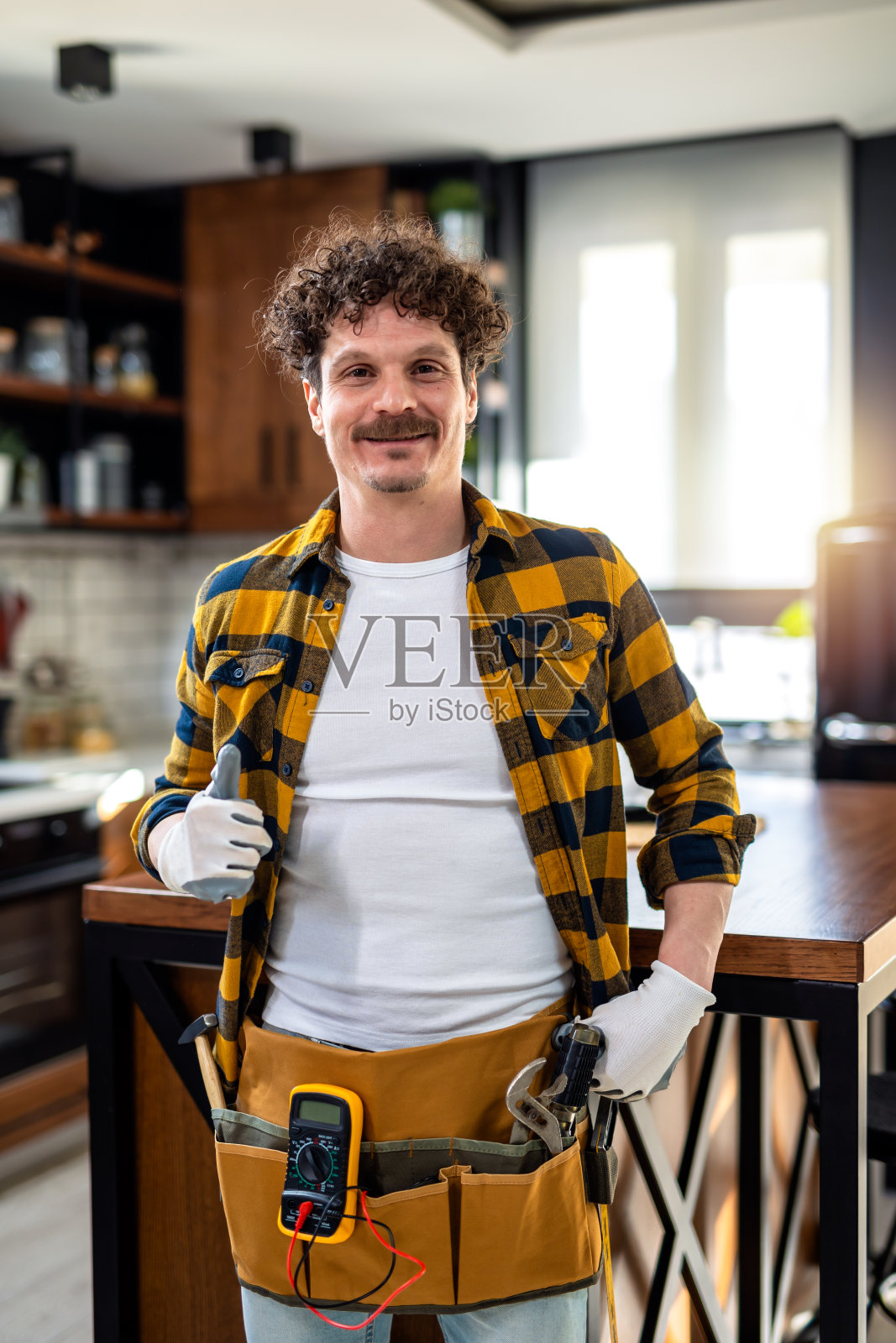 拉丁裔杂工的肖像。带着设备站在厨房里。照片摄影图片