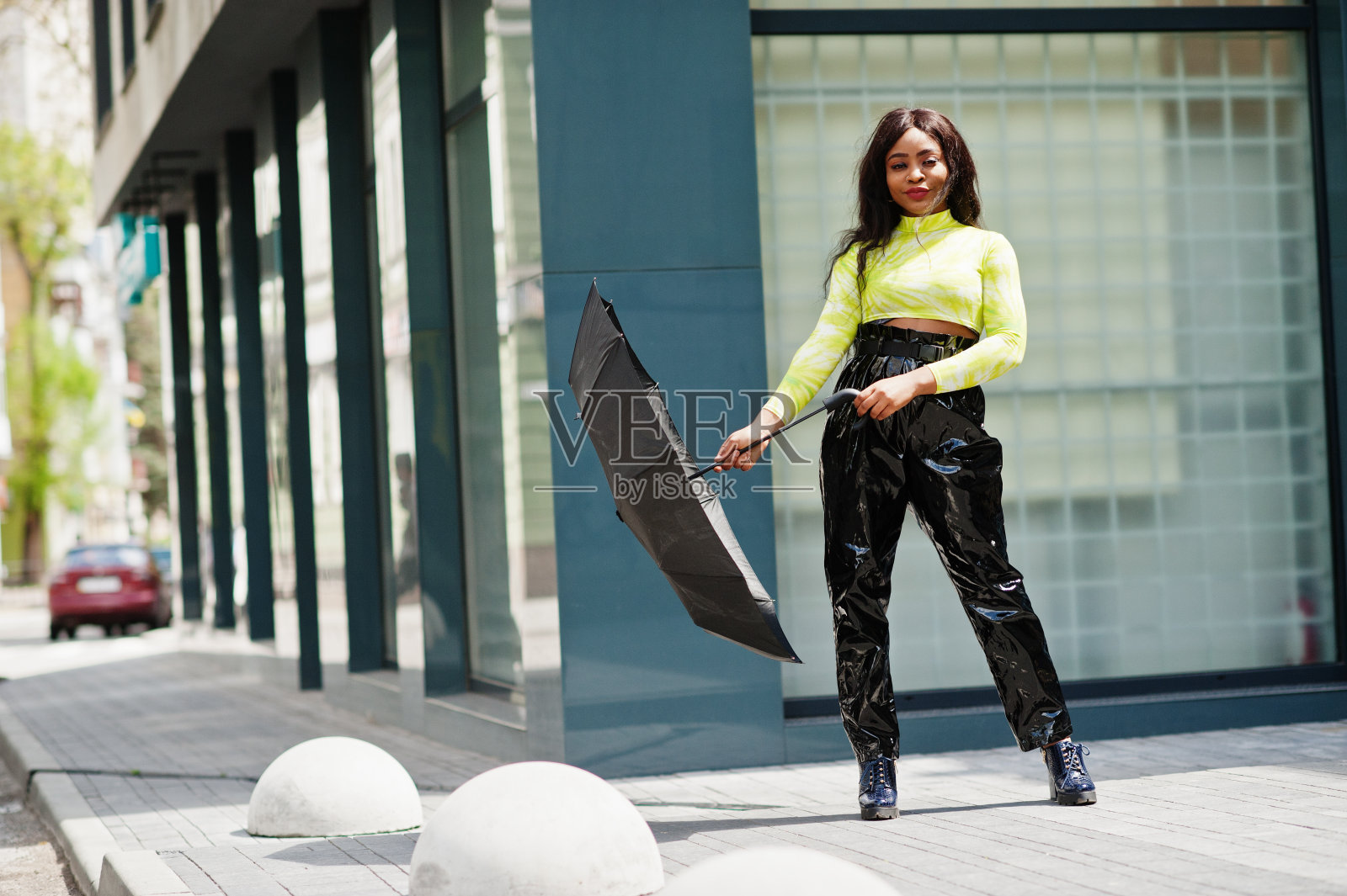 年轻美丽的非裔美国妇女手持黑伞的肖像。照片摄影图片