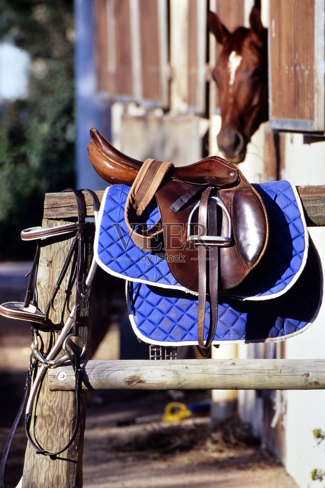 马的鞍放在马厩前面照片摄影图片