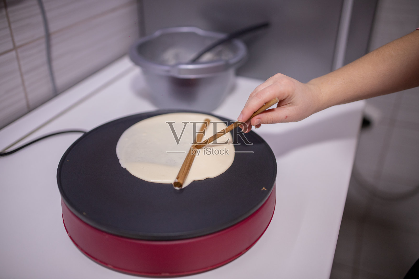 女人用电动煎饼机做美味的薄饼照片摄影图片