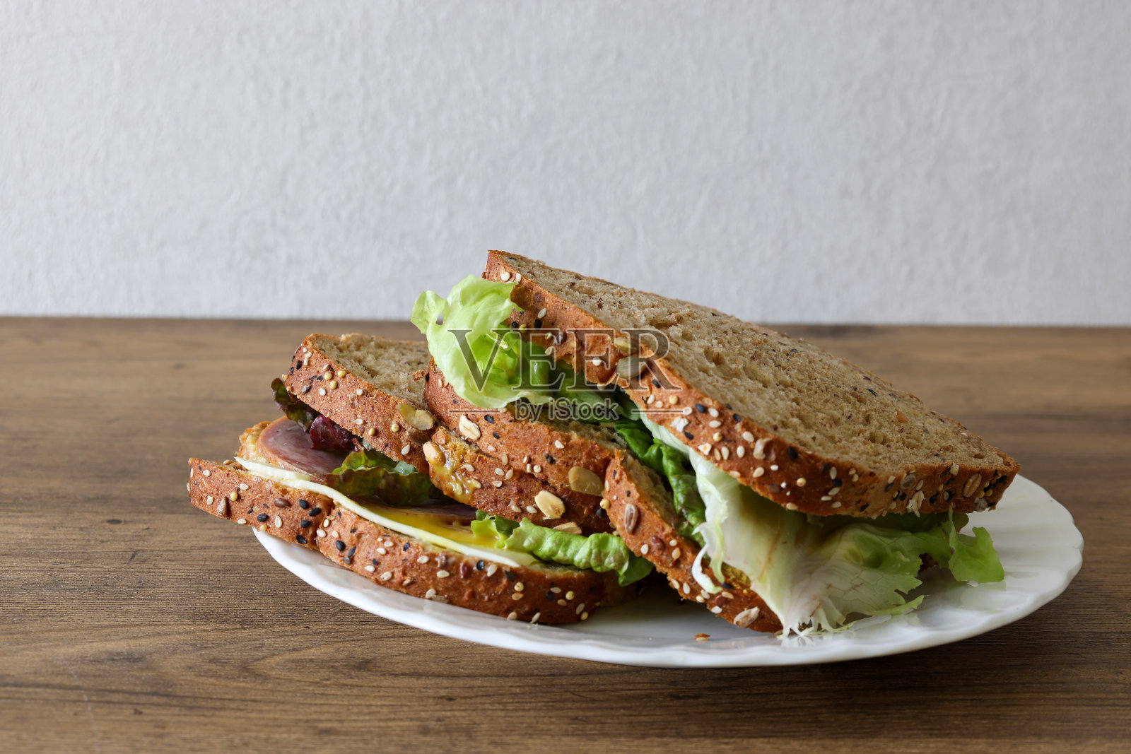 有机三明治放在盘子里，隔在木制背景上。照片摄影图片